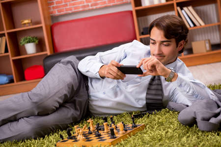 Young handsome boss playing chess during breakの写真素材