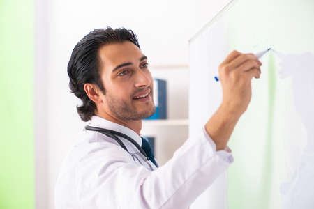 Young doctor in front of whiteboardの写真素材