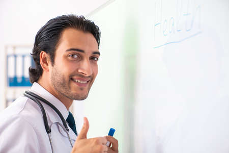 Young doctor in front of whiteboardの写真素材