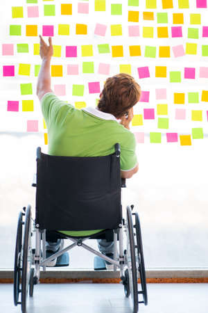 Young student in wheelchair with many conflicting prioritiesの写真素材