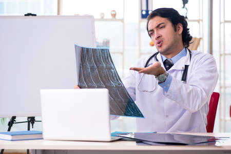 Young handsome male radiologist in front of whiteboard