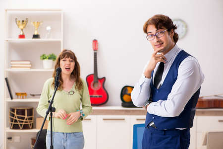 Young woman during music lesson with male teacherの写真素材