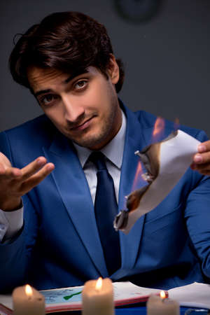 Businessman burning the evidence late in officeの写真素材