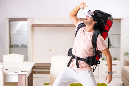 Young male tourist with virtual glasses preparing for trip