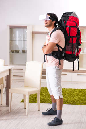Young male tourist with virtual glasses preparing for tripの写真素材