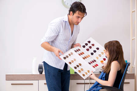 Young woman visiting young handsome barberの写真素材