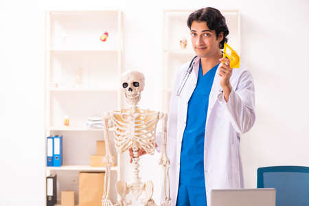 Young male doctor with skeleton