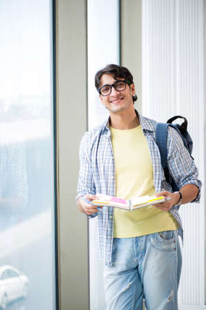 Young handsome student standing at the windowの写真素材
