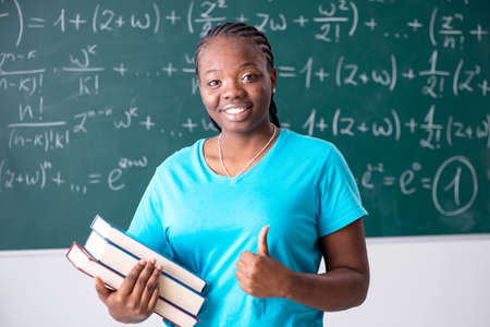 Black female student in front of chalkboardの写真素材
