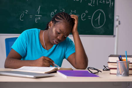 Black female student in front of chalkboardの写真素材