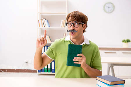 Student with fake moustache reading bookの写真素材