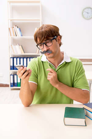 Student with fake moustache reading bookの写真素材