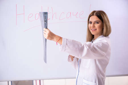 Young female doctor standing in front of the white boardの写真素材