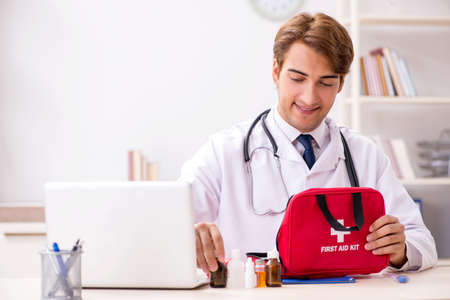 Young doctor with first aid kit in hospitalの写真素材