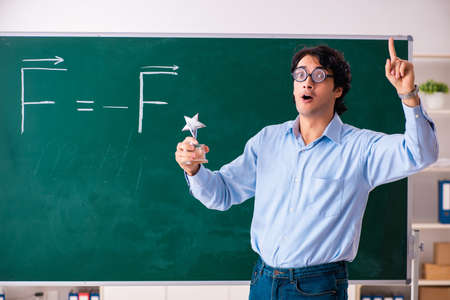 Young male physic standing in front of the green boardの写真素材