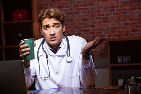 Young handsome doctor working night time at the hospitalの写真素材