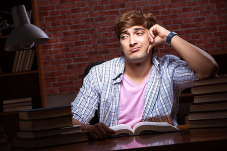 Young handsome student preparing for exams at night