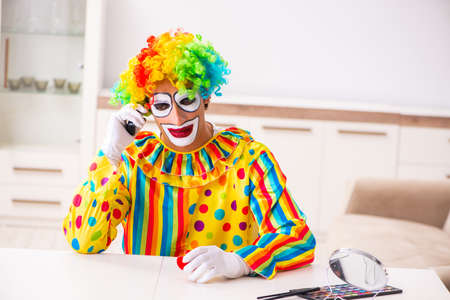 Male clown preparing for perfomance at home