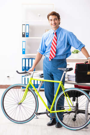 Young businessman using bike to commute to the officeの写真素材
