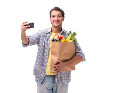 Young man with his grocery shopping on whiteの写真素材
