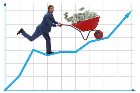 Businessman pushing wheelbarrow full of dollar moneyの写真素材