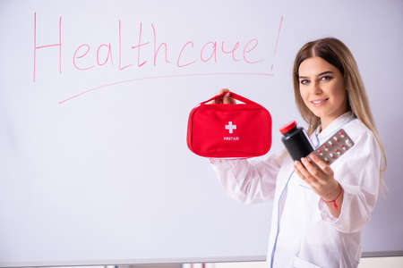 Young female doctor standing in front of the white board