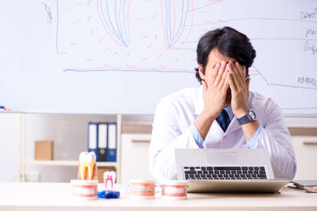 Young handsome dentist in front of the whiteboardの写真素材