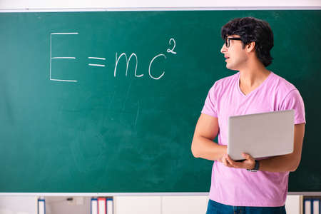 Young male physic standing in front of the green board