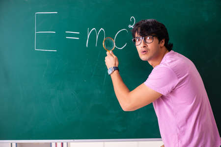 Young male physic standing in front of the green board