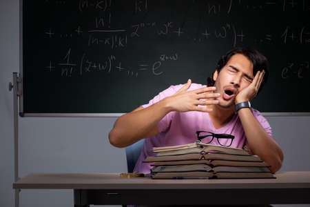 Young male student sitting in classroomの写真素材