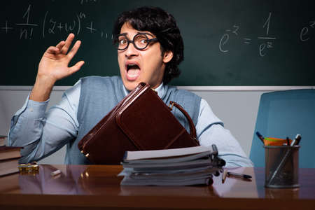 Young math teacher in front of chalkboardの写真素材