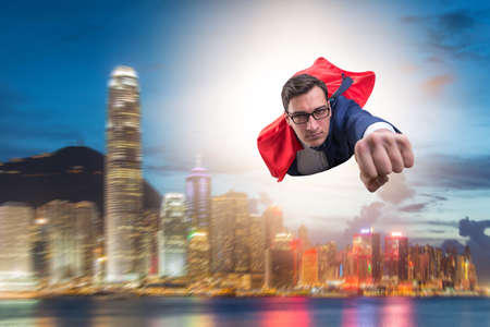 Superhero businessman flying over the cityの写真素材