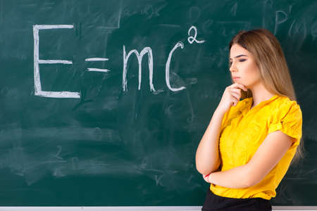 Young female student in front of the chalkboardの写真素材