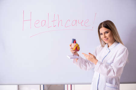 Young female doctor standing in front of the white boardの写真素材