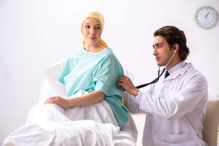 Young handsome doctor visiting female oncology patient