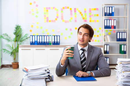 Young handsome employee sitting at the officeの写真素材