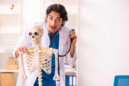 Young male doctor with skeletonの写真素材
