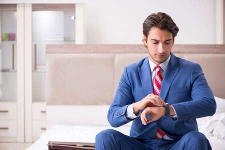 Young employee working at home sitting on the bedの写真素材