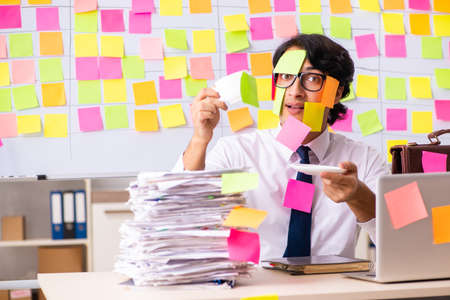Young employee in conflicting priorities conceptの写真素材