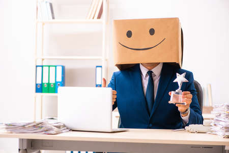 Happy man employee with box instead of his headの写真素材