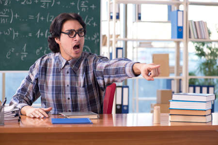 Young funny math teacher in front of chalkboardの写真素材