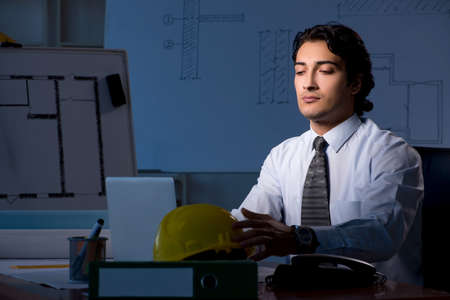 Young construction architect working on project at night