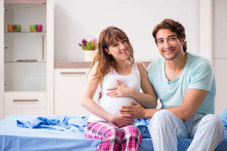 Pregnant woman with husband in the bedroom