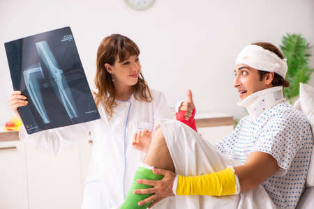 Young doctor examining injured patient