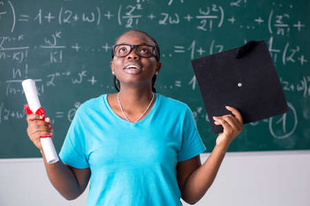 Black female student in front of chalkboardの写真素材