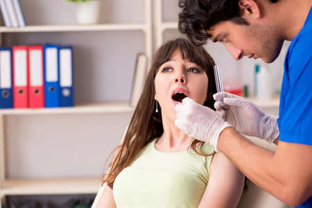 Doctor getting saliva test sample in clinic hospitalの写真素材