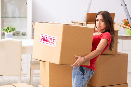 Young beautiful woman moving to new flat