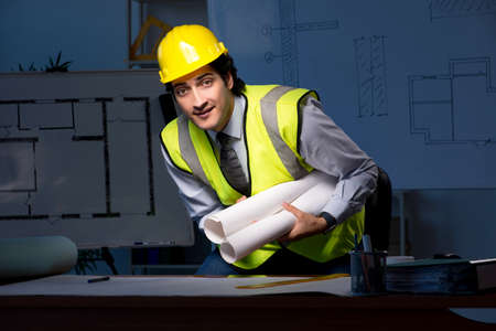 Young construction architect working on project at night
