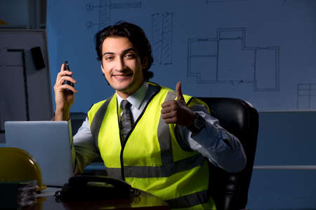 Young construction architect working on project at night