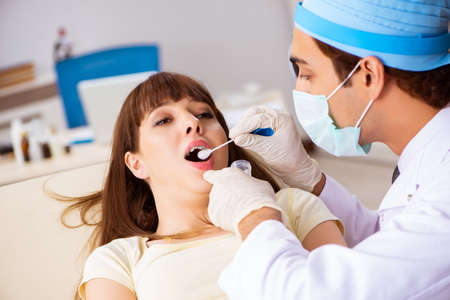 Young woman visting male doctor otolaryngologistの写真素材